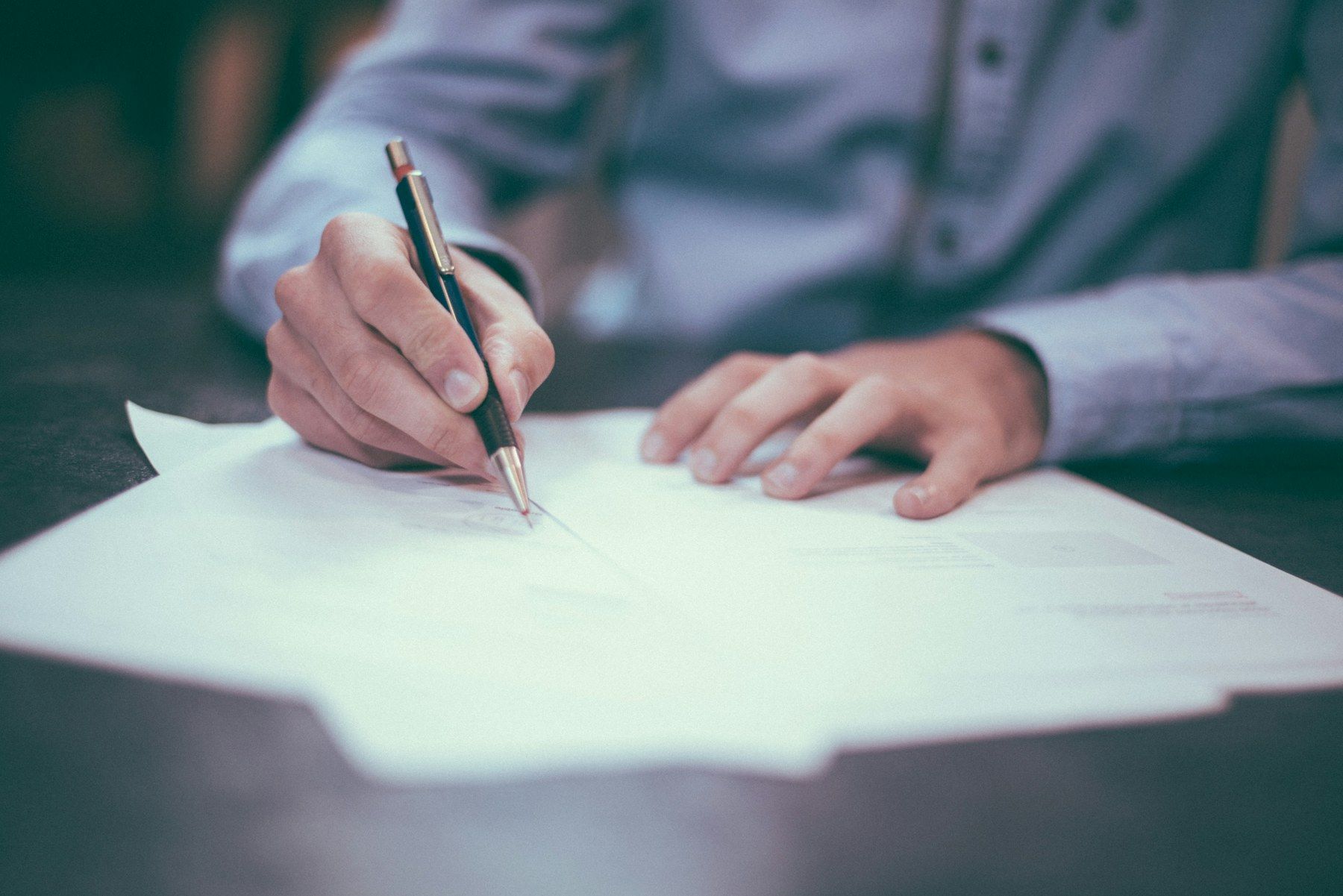 A professional signing documents at a desk