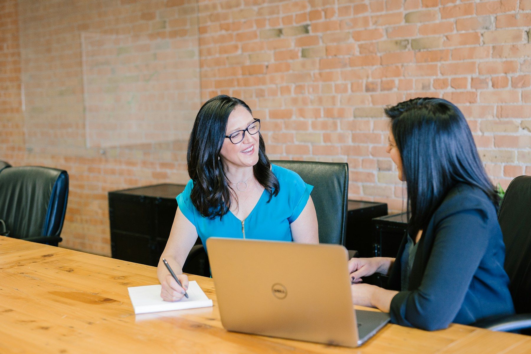 An adviser smiling while meeting a client across a desk