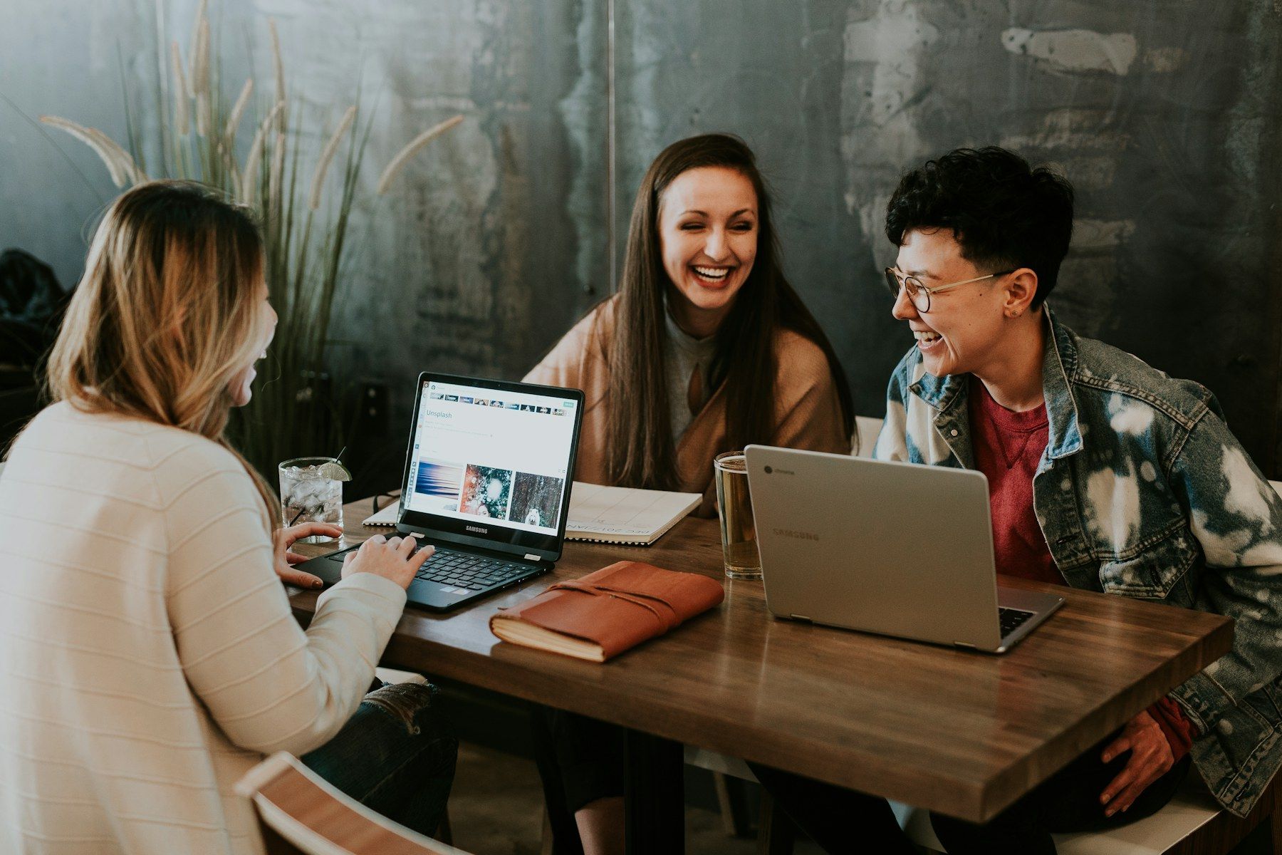 Young entrepreneurs working together on laptops in a café